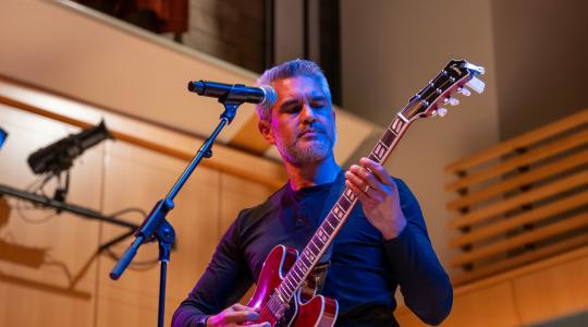 Sonoma State University Professor Eric Cabalo plays an electric guitar during May 2 Rock Collegium performance.
