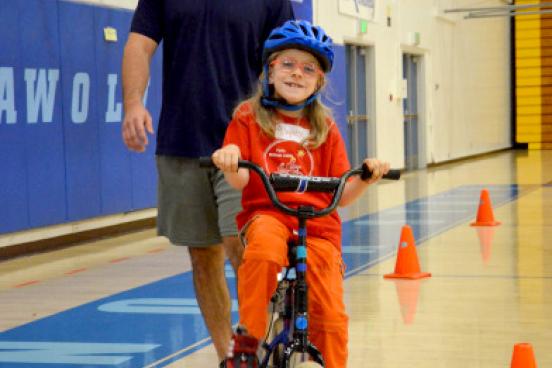 child on bike with instructor following