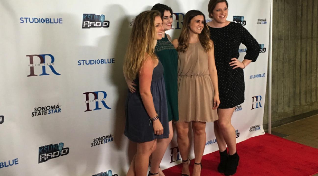 students posing for pictures at the red carpet 