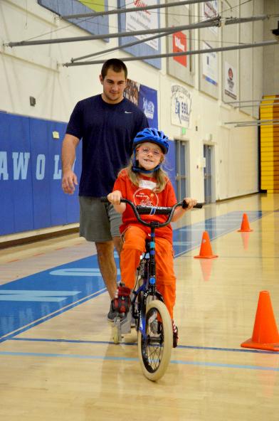 girl riding bicycle in gym