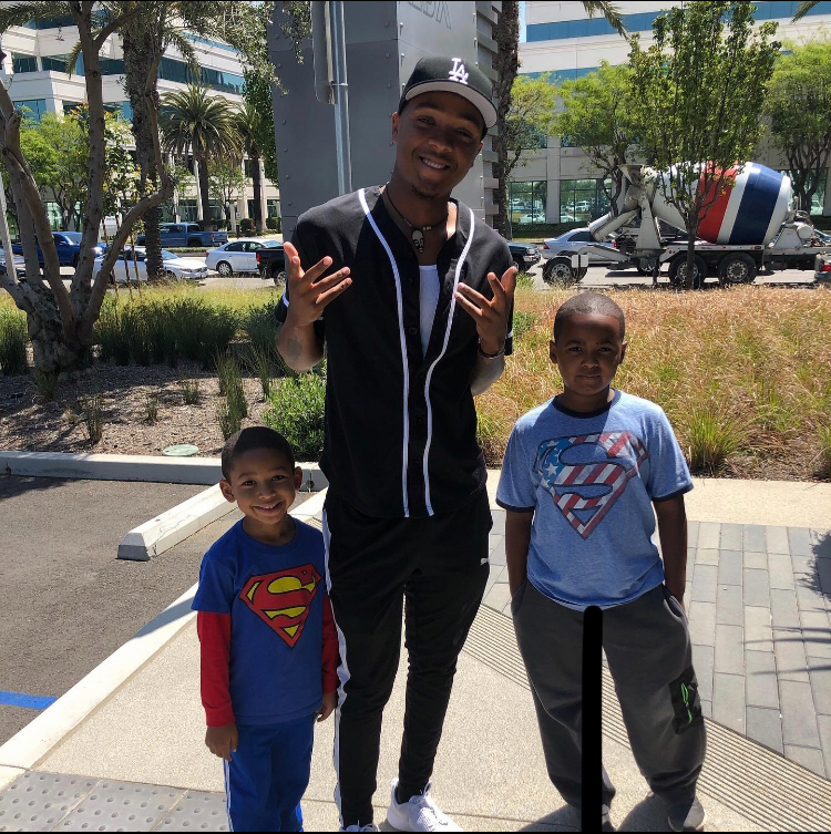 Elijah poses for a photo with a pair of young family members