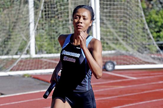 Angelique Lopez running with the baton at a track meet