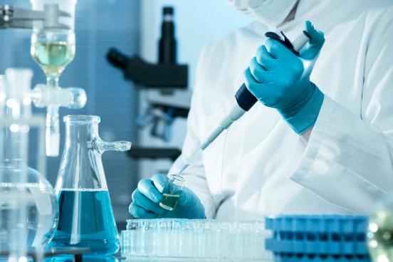 chemist injecting blue liquid into container