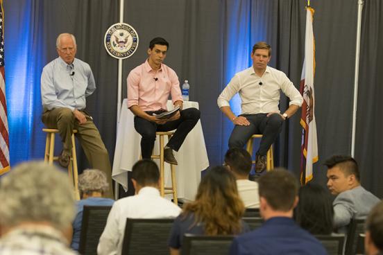 Congressman Michael Thompson and Eric Sewell sitting on stools on stage with student moderator