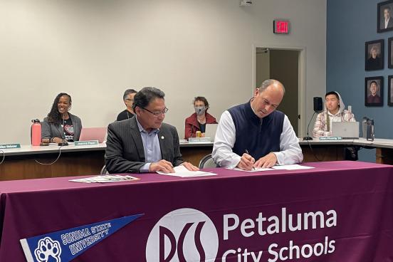 Sonoma State University Interim President Mike Lee and Petaluma City Schools Superintendent Matthew Harris sign a "Promise" agreement.