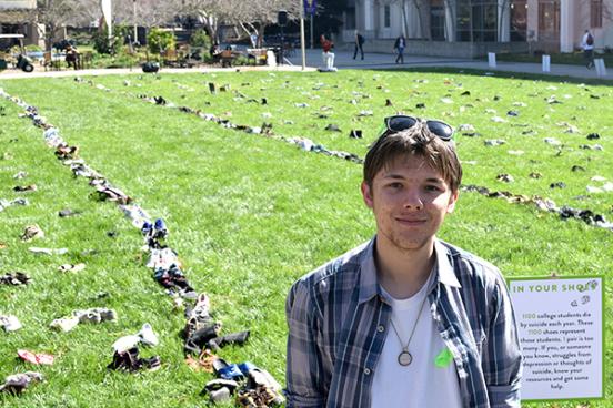 Ben Teurlay started the In Your Shoes project to raise awareness for suicide prevention. // Photo by Nicolas Grizzle Ben Teurlay next to his art piece