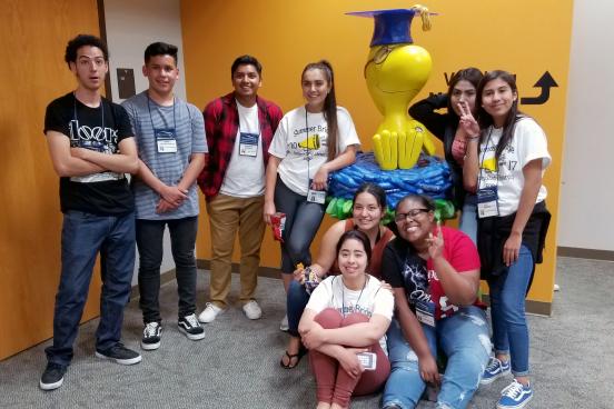 students pose with Woodstock sculpture in library