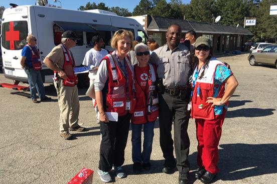  Ann Gang, Sally Bowers, a local police officer and Kathy De Bel help residents recover from Hurricane Matthew in North Carolina.