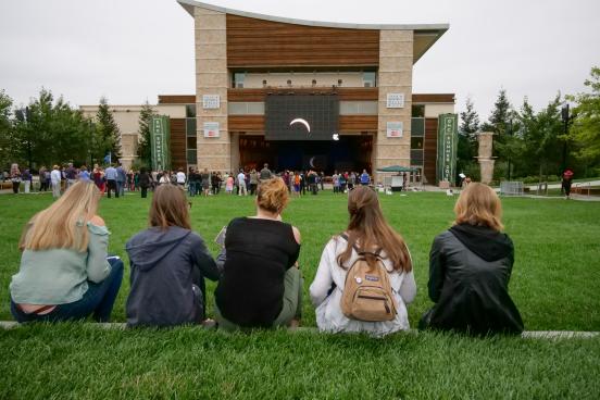 Students watch the eclipse on the big screen outside Weill Hall