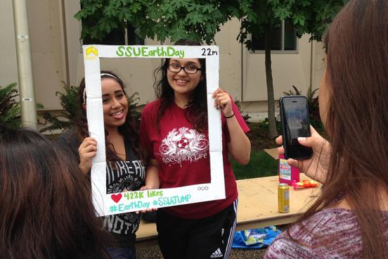 students pose for photo at earth day event on campus