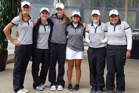 women's golf holds second place trophy