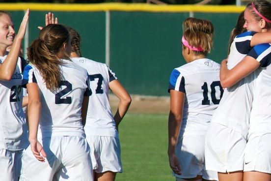 women's soccer celebrating goal
