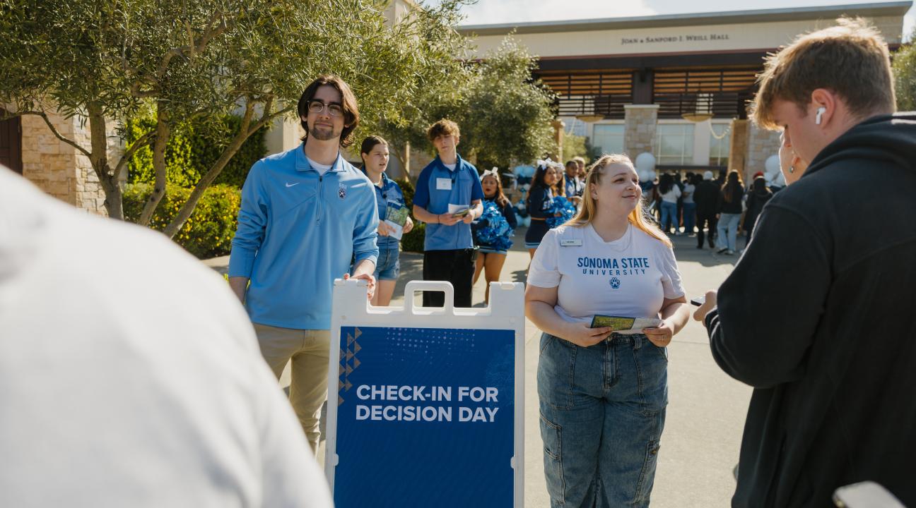 Sonoma State University student ambassador Denise Bevis (right, facing camera) greets prospective students at SSU Decision Day 2024