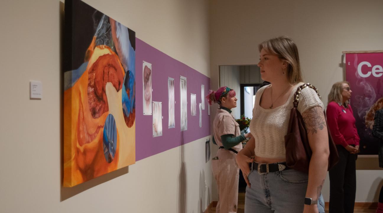 Gallery guest viewing medical portrait at "In Vivo: Within the Living" at Sonoma State's University Art Gallery
