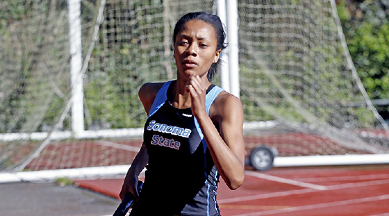 Angelique Lopez running with the baton at a track meet