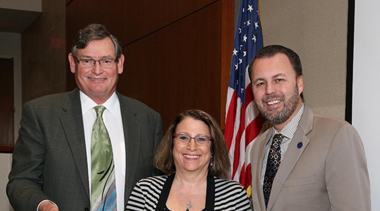 CSU Chancellor Timothy White and Chair of the Board of Trustees, Lou Monville present SSU physics and astronomy professor Lynn Cominsky with the Wang Family Excellence Award