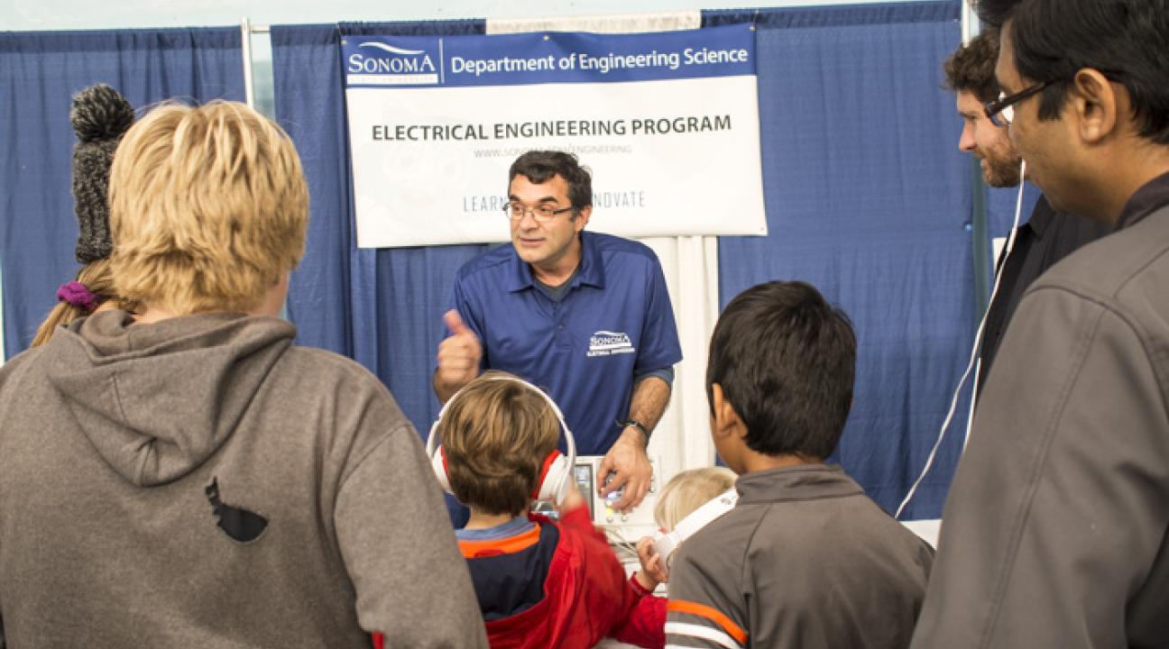 professor giving thumbs up to group of young students