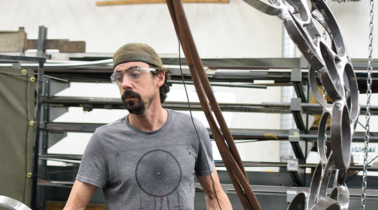 Andrew Scanlon works on "Holons," a steel sculpture on display as part of Commence: Sculpture projects 2015