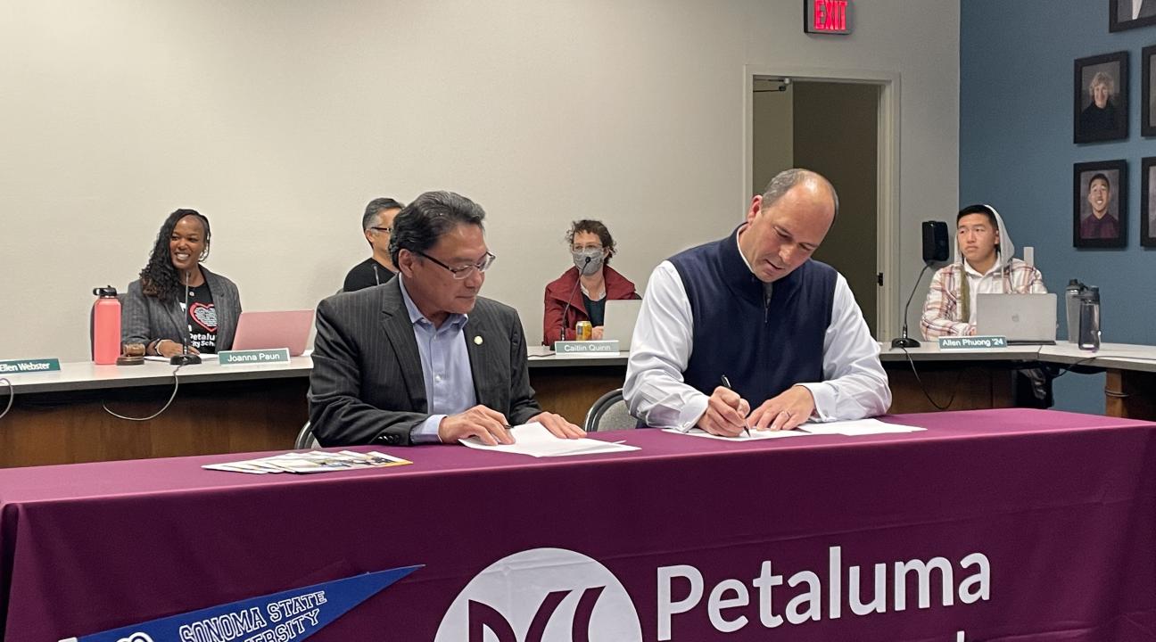 Sonoma State University Interim President Mike Lee and Petaluma City Schools Superintendent Matthew Harris sign a "Promise" agreement.