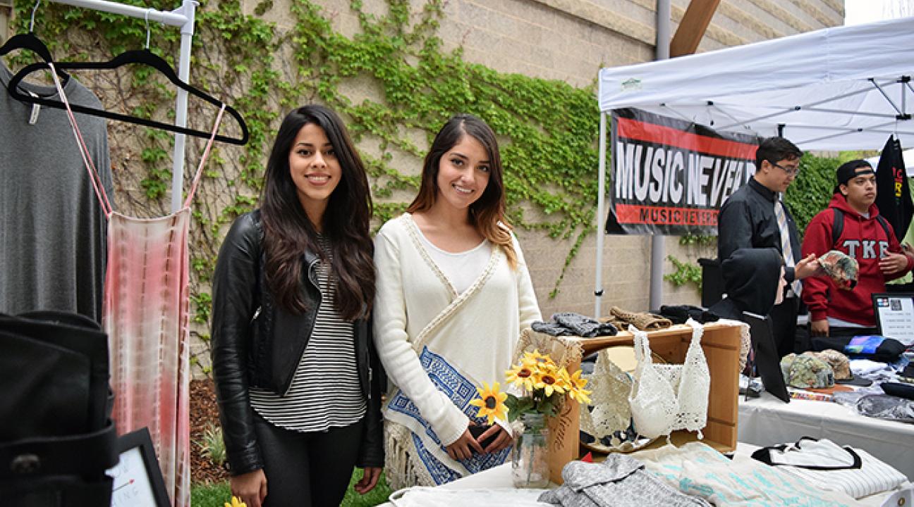 two women selling clothes at booth