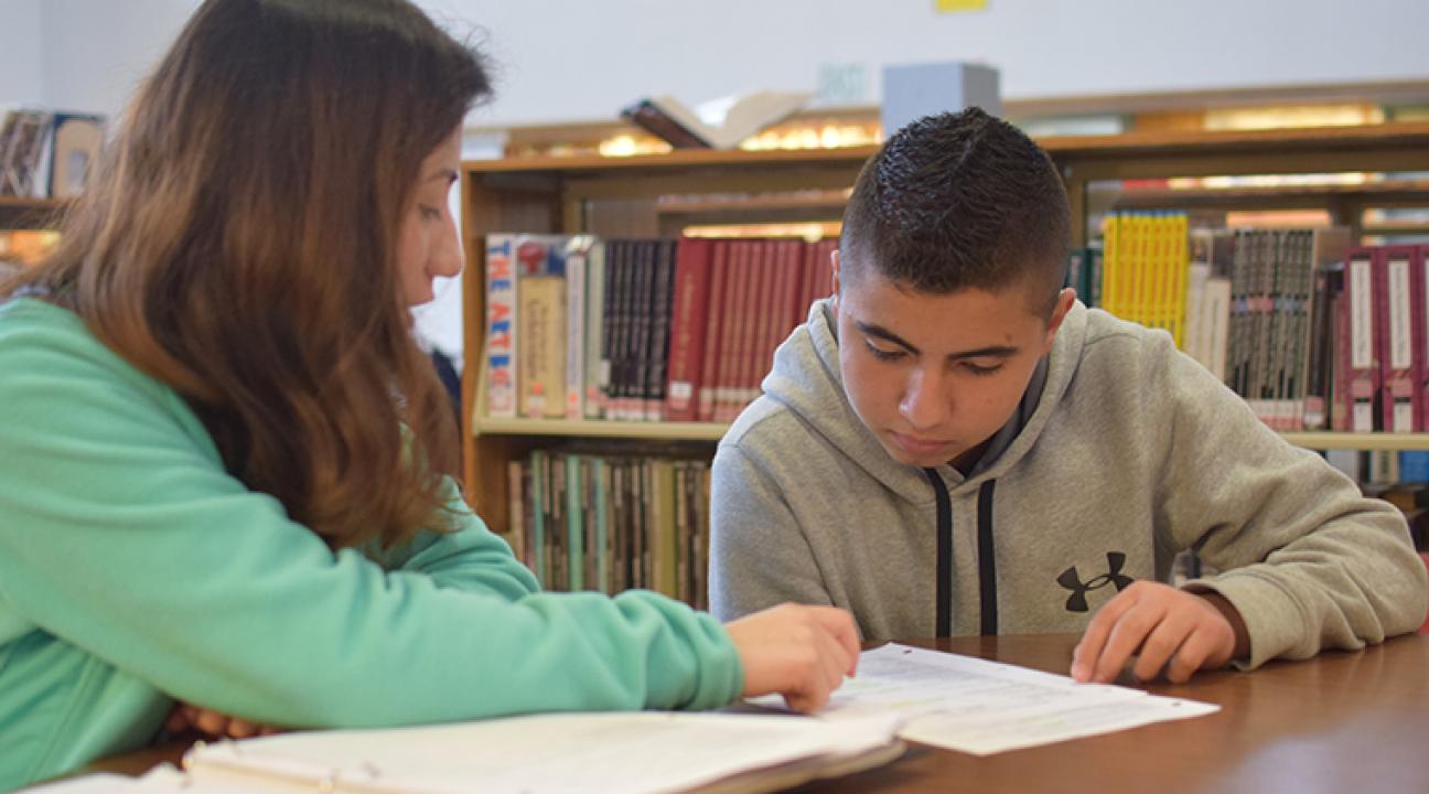 Teacher working with young Hispanic student
