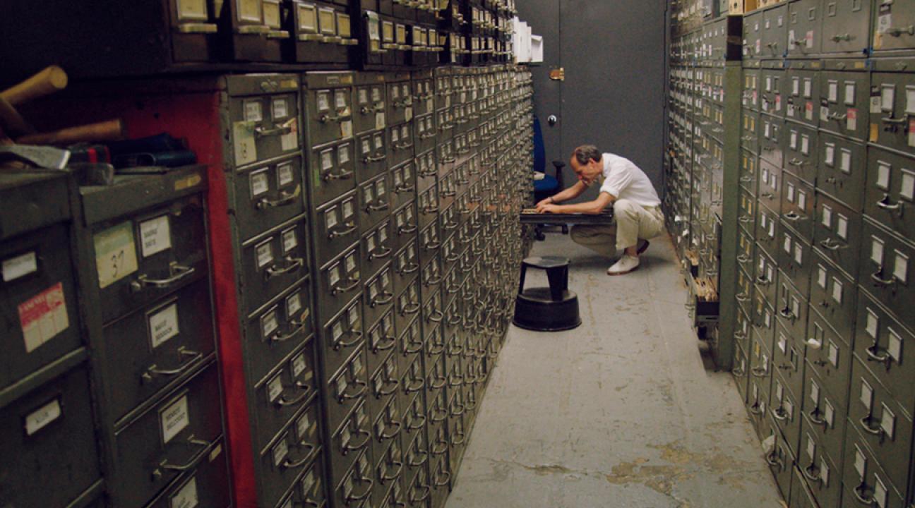 Still from Vanessa Gould's documentary film "Obit." (2016). Journalist looking through cabinets
