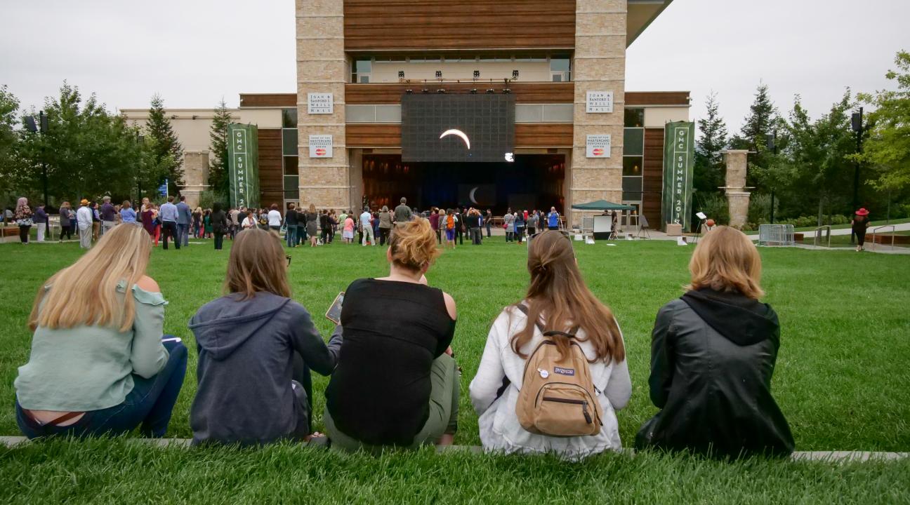 Students watch the eclipse on the big screen outside Weill Hall