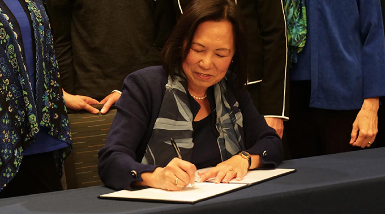 President Judy K. Sakaki signs President's Climate Commitment 