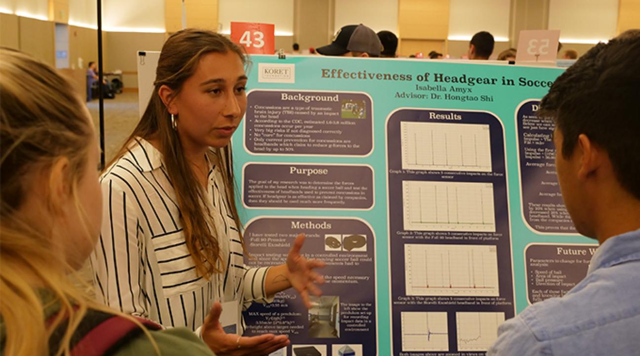 Students shows her project about headgear in soccer to students 