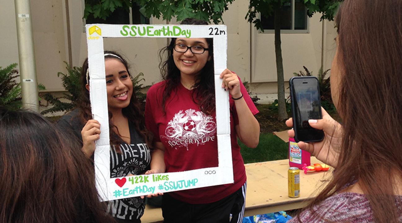 students pose for photo at earth day event on campus