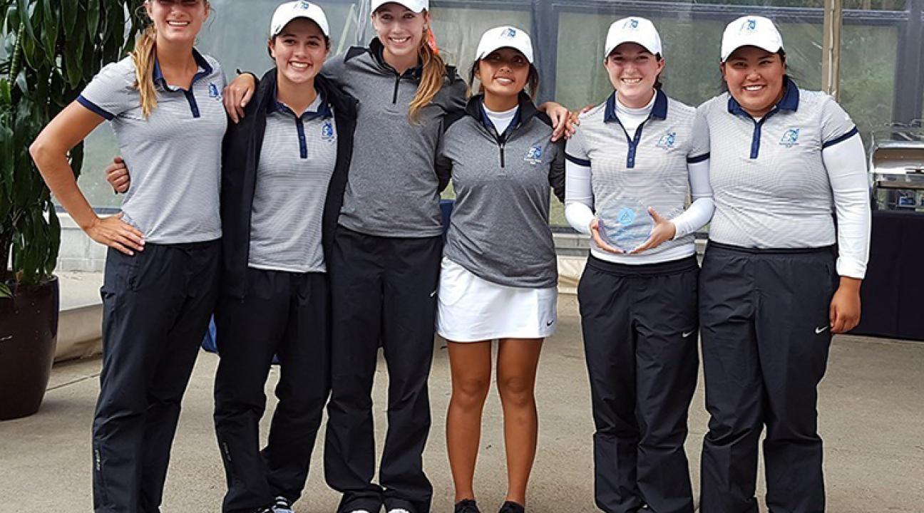 women's golf holds second place trophy