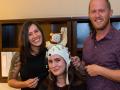 Student Olivia Krieger, left, and Professor Jesse Bengson demonstrate a cap used to record brainwaves with student Alexandra Theodoroub