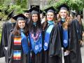 four students in regalia at commencement