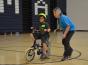 elaine mchugh helping a child ride a bike