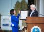 Rep. Mike Thompson hands President Judy K. Sakaki a copy of a Congressional Resolution honoring Sonoma State for the opening of the WSLC.