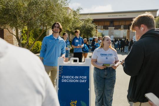 Sonoma State University student ambassador Denise Bevis (right, facing camera) greets prospective students at SSU Decision Day 2024
