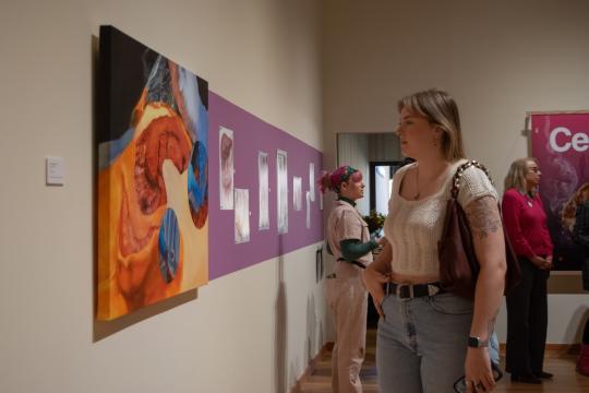 Gallery guest viewing medical portrait at "In Vivo: Within the Living" at Sonoma State's University Art Gallery