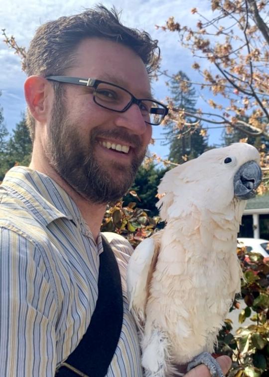 Toby Dodgen posing with a white parrot