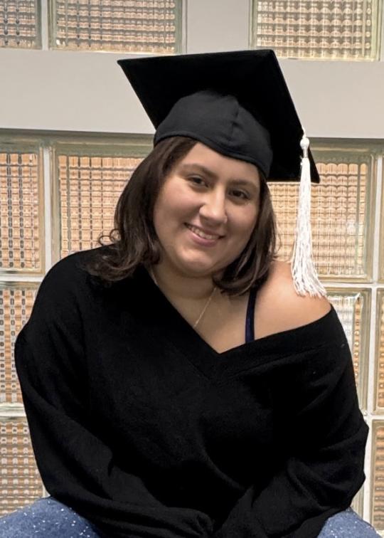 Faith Whitton posing while wearing a graduation cap