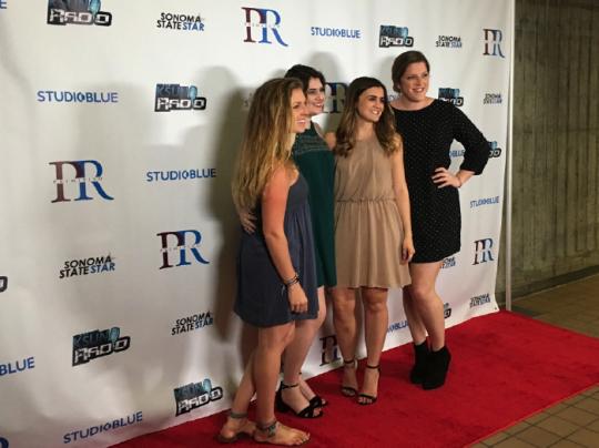 students posing for pictures at the red carpet 