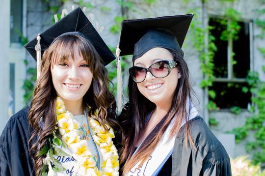 two students pose for a picture with their cap and gown