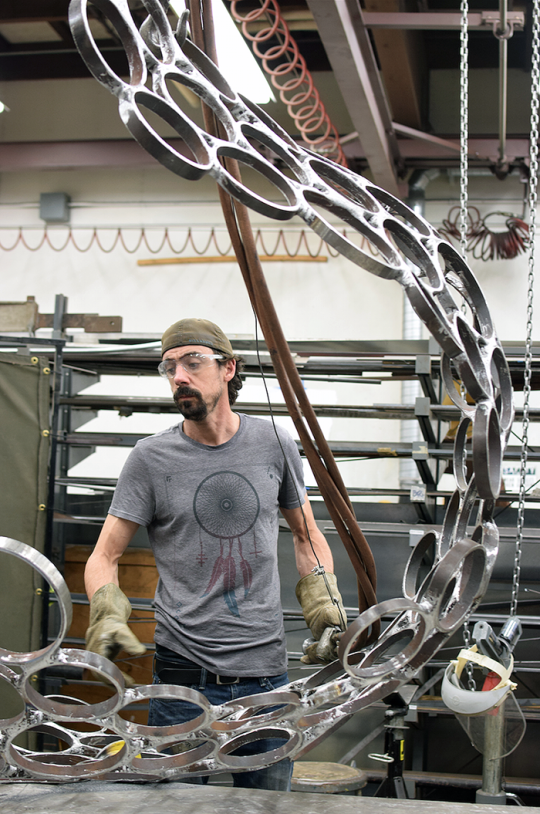 Andrew Scanlon works on "Holons," a steel sculpture on display as part of Commence: Sculpture projects 2015