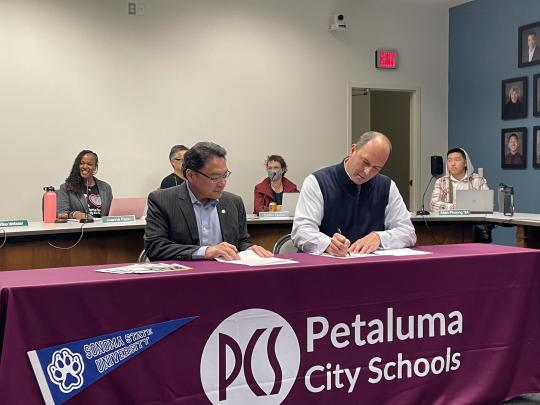 Sonoma State University Interim President Mike Lee and Petaluma City Schools Superintendent Matthew Harris sign a "Promise" agreement.