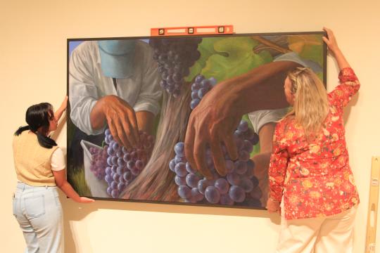 From left: Raiven Reyna, a third year art history major works with Gallery Exhibition Manager Carla Stone with exhibition installation. 