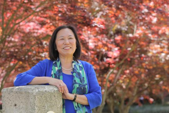 Image of Judy K. Sakaki in front of tree during the autumn.