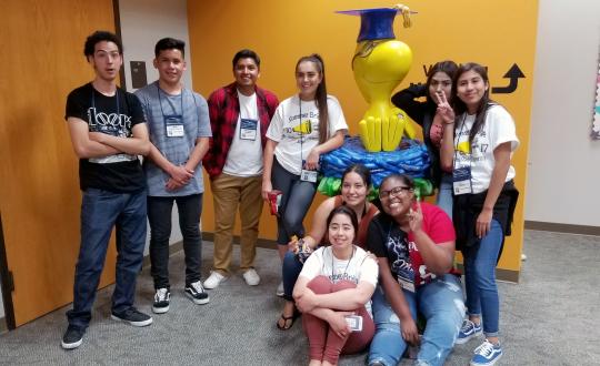 students pose with Woodstock sculpture in library