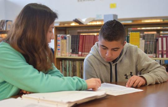 Teacher working with young Hispanic student