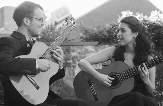 man and woman with acoustic guitars