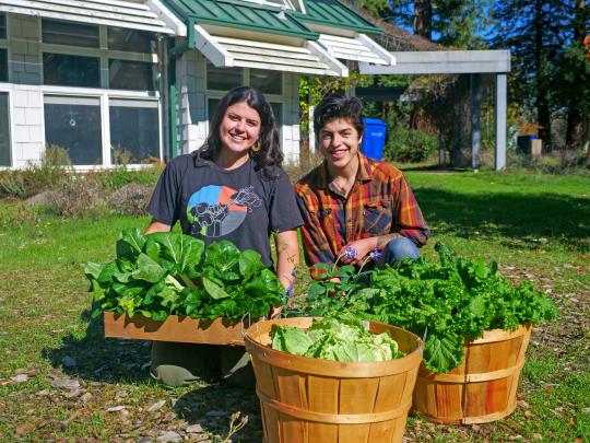 Sophia Pruden and Evangelina Austin pose with vegetables