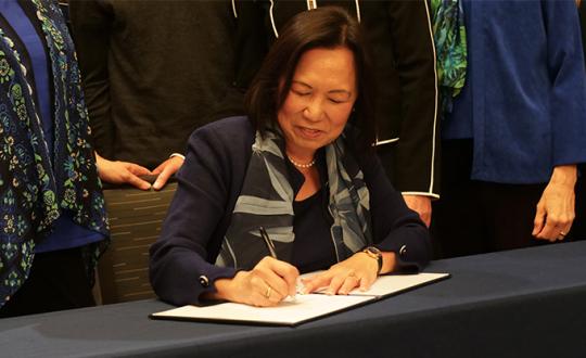 President Judy K. Sakaki signs President's Climate Commitment 